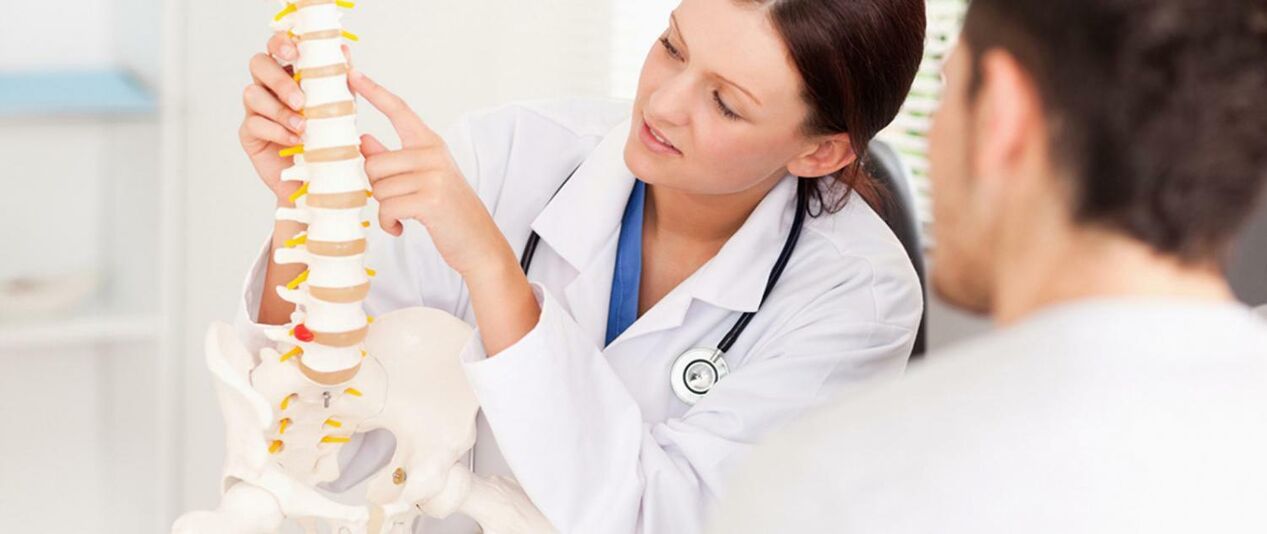 Der Arzt informiert den Patienten über den Entstehungsmechanismus einer Osteochondrose der Brustwirbelsäule. 
